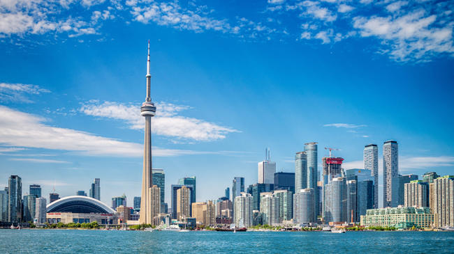 a city skyline with a tall tower and a body of water