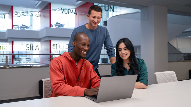 a group of people looking at a laptop