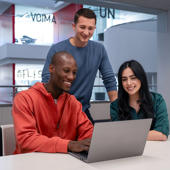 a group of people looking at a laptop