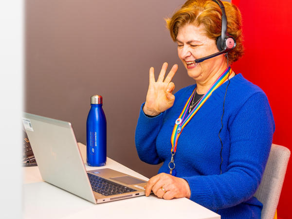 une personne portant des écouteurs et assise à un bureau avec un ordinateur portable
