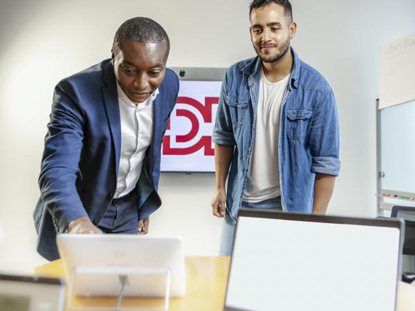 Zwei Männer, die auf einen Laptop schauen