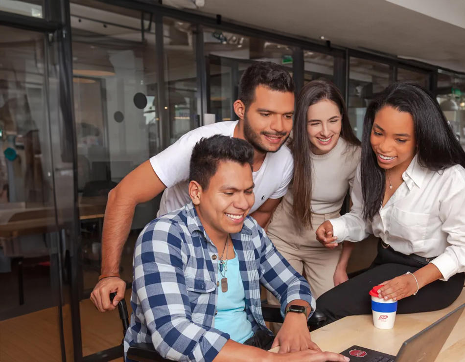 um grupo de pessoas olhando para um laptop