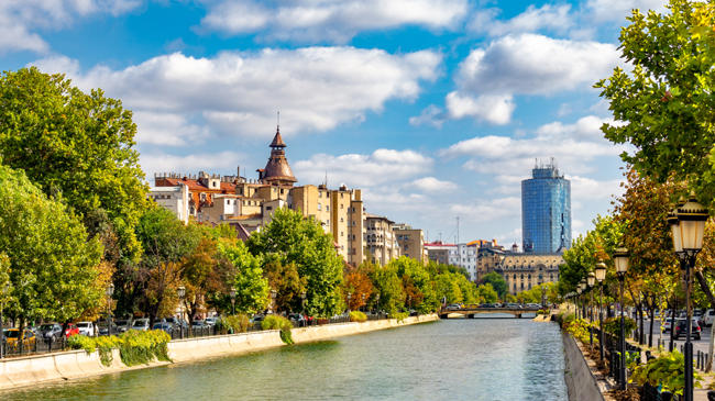 a river with trees and buildings in the background