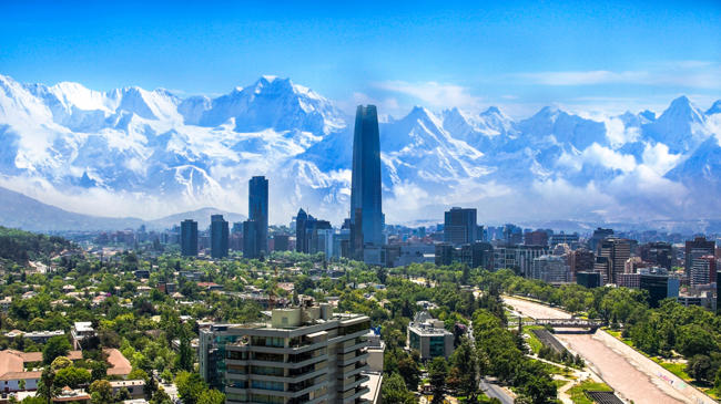 a city with trees and mountains in the background