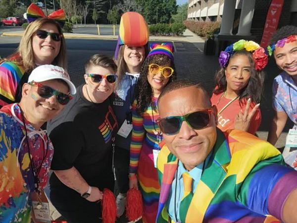 a group of people wearing sunglasses and rainbow clothes