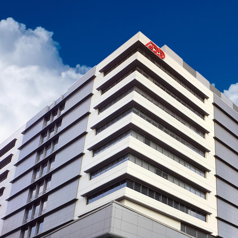 un bâtiment avec un ciel bleu et des nuages