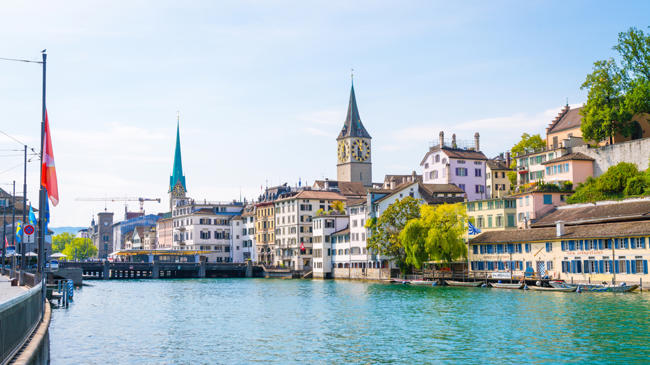 a body of water with buildings and a tower