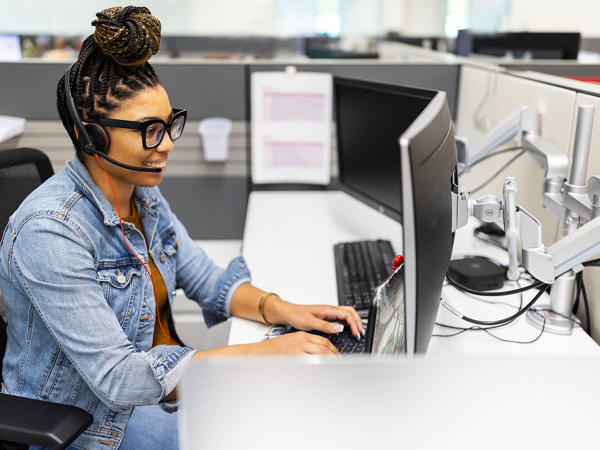 une personne assise à un bureau avec un casque d’écoute sur